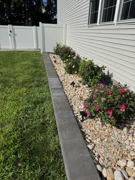 Flower bed along the side of the home after weeding, trimming, and cleanup.